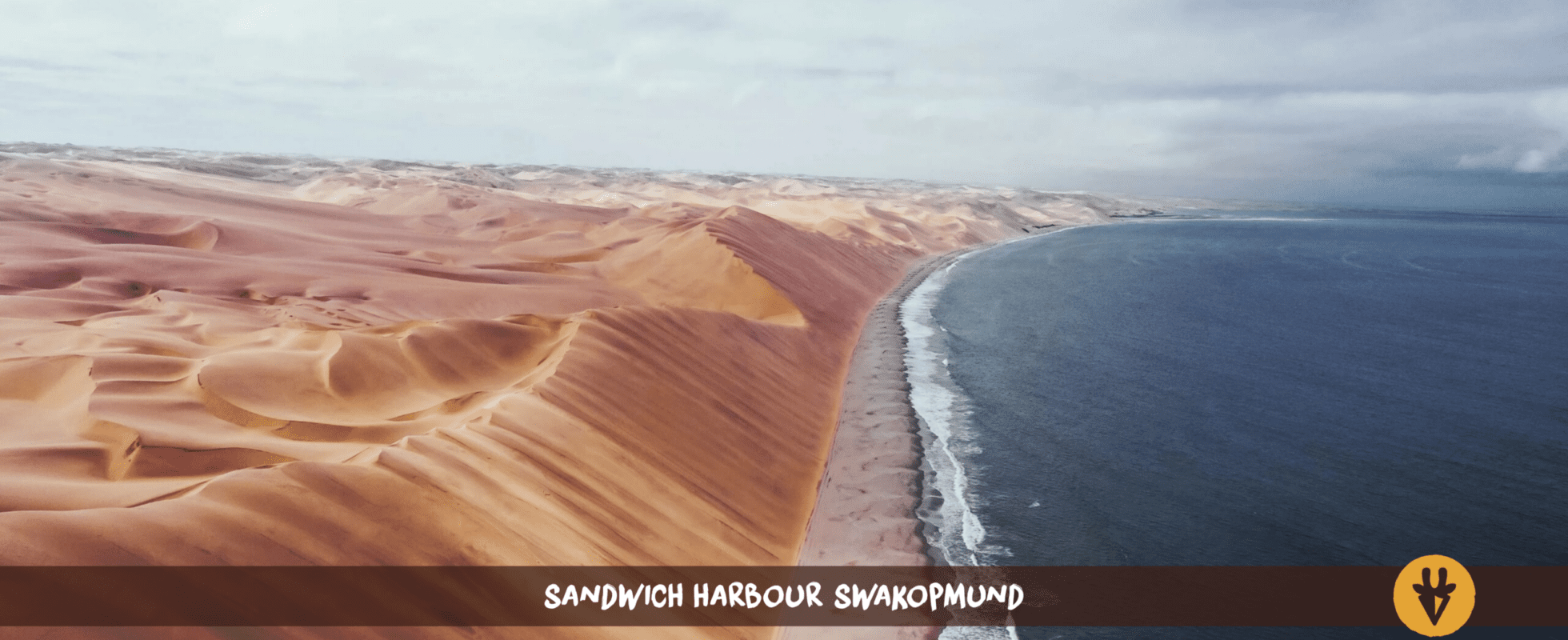 Sand dunes and the ocean at Sandwich Harbour in Namibia
