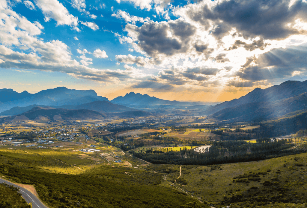Tierras vinícolas con nubes y rayos de sol